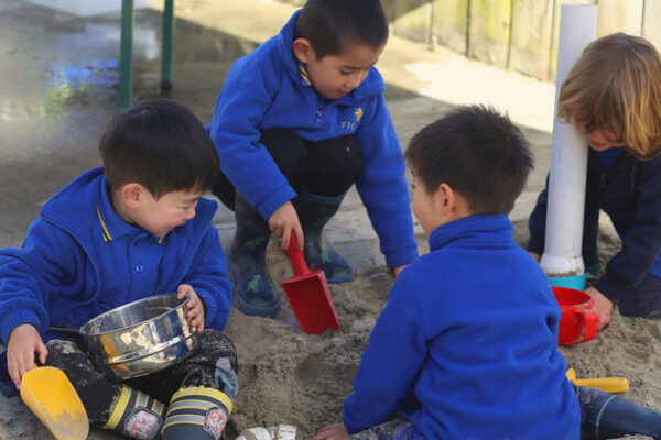 Ficino-Montessori-Preschool-Gallery 3 Four children playing in a sandpit at a private Montessori preschool in Mt Eden Auckland